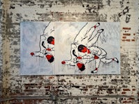two paintings hanging on a brick wall
