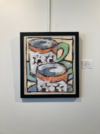 a painting of coffee cups hanging on a wall