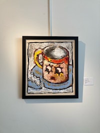 a painting of a coffee cup hanging on a wall